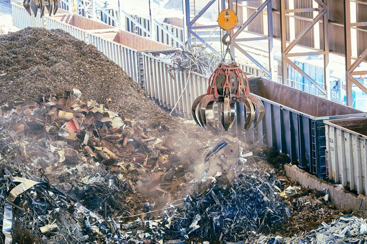 Pulpo de chatarra alimentando una línea de reciclaje de metal