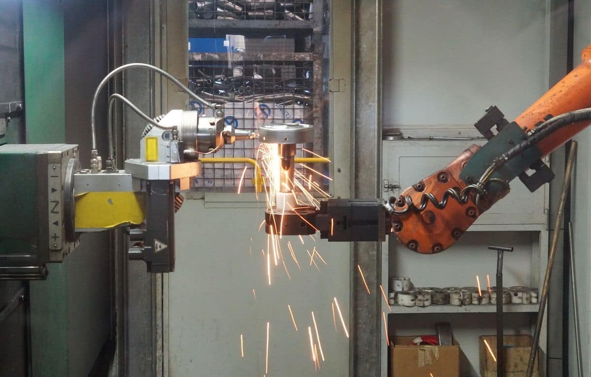 Brazo robótico soldando una pieza en una línea de producción automatizada