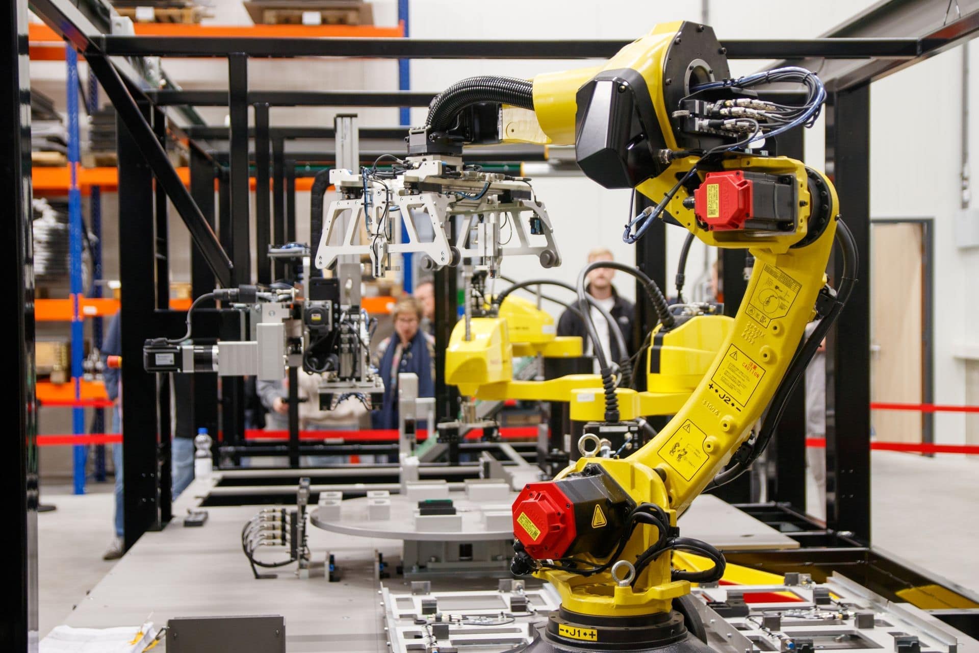 Robots industriales amarillos en una célula de montaje automatizada de una línea de producción