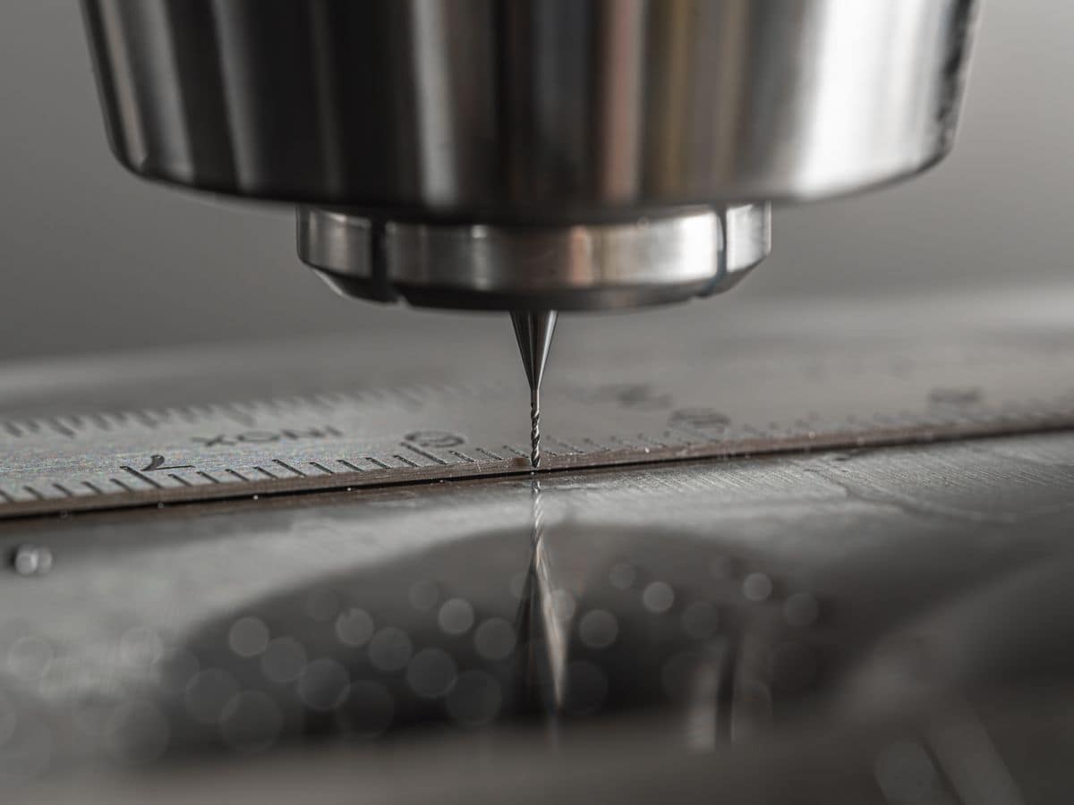 Gros plan d’une broche de fraiseuse CNC au-dessus d’une pièce en acier