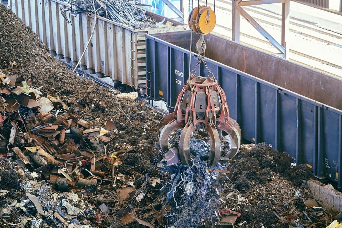 Benna a polipo sospesa su un mucchio di rottami metallici misti in un impianto di riciclo