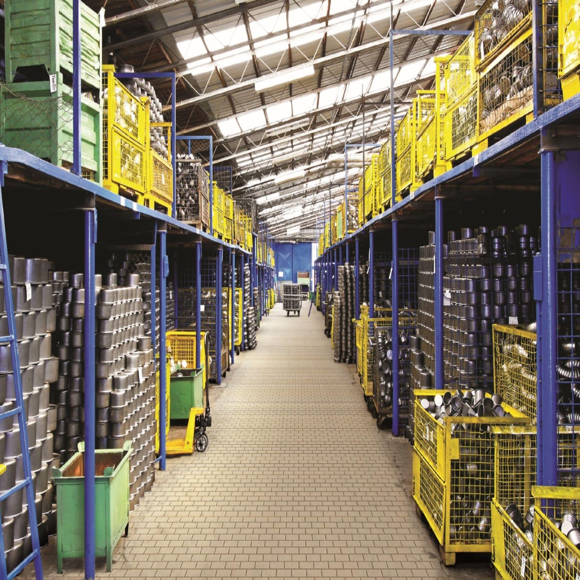 Warehouse aisle with mesh pallet cages full of steel fittings